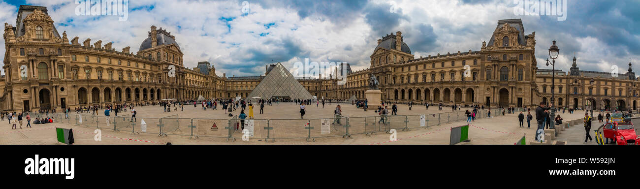 Mega grande foto panoramica del museo del Louvre con la piramide di vetro fiancheggiata dal Richelieu e Denon ala dietro la folla di metallo barriere al posto... Foto Stock