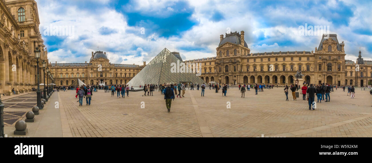 Grande foto panoramica del famoso Museo del Louvre con la mitica piramide in vetro. I visitatori sono attorno a piedi e ammirate la straordinaria architettura... Foto Stock