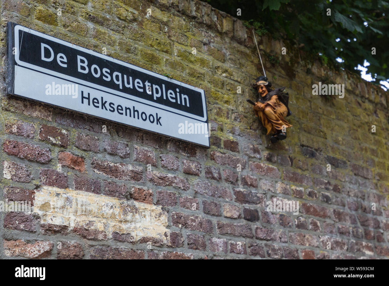 Il nome della strada segno nel dialetto di Maastricht (heksenhook = angolo della strega) con una scultura di accompagnamento del nome della strada a Maastricht Foto Stock