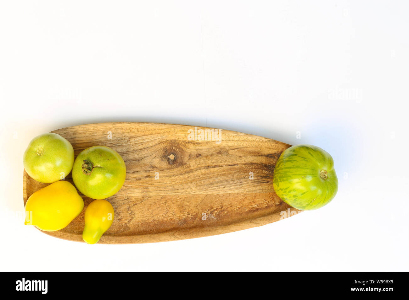 Grüne Tomaten auf Holzbrett Hintergrund Foto Stock