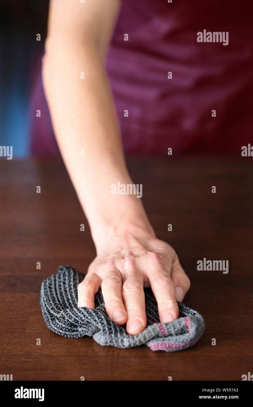 Igiene domestica. Close-up di pulitura a mano una famiglia in superficie con un panno. Foto Stock