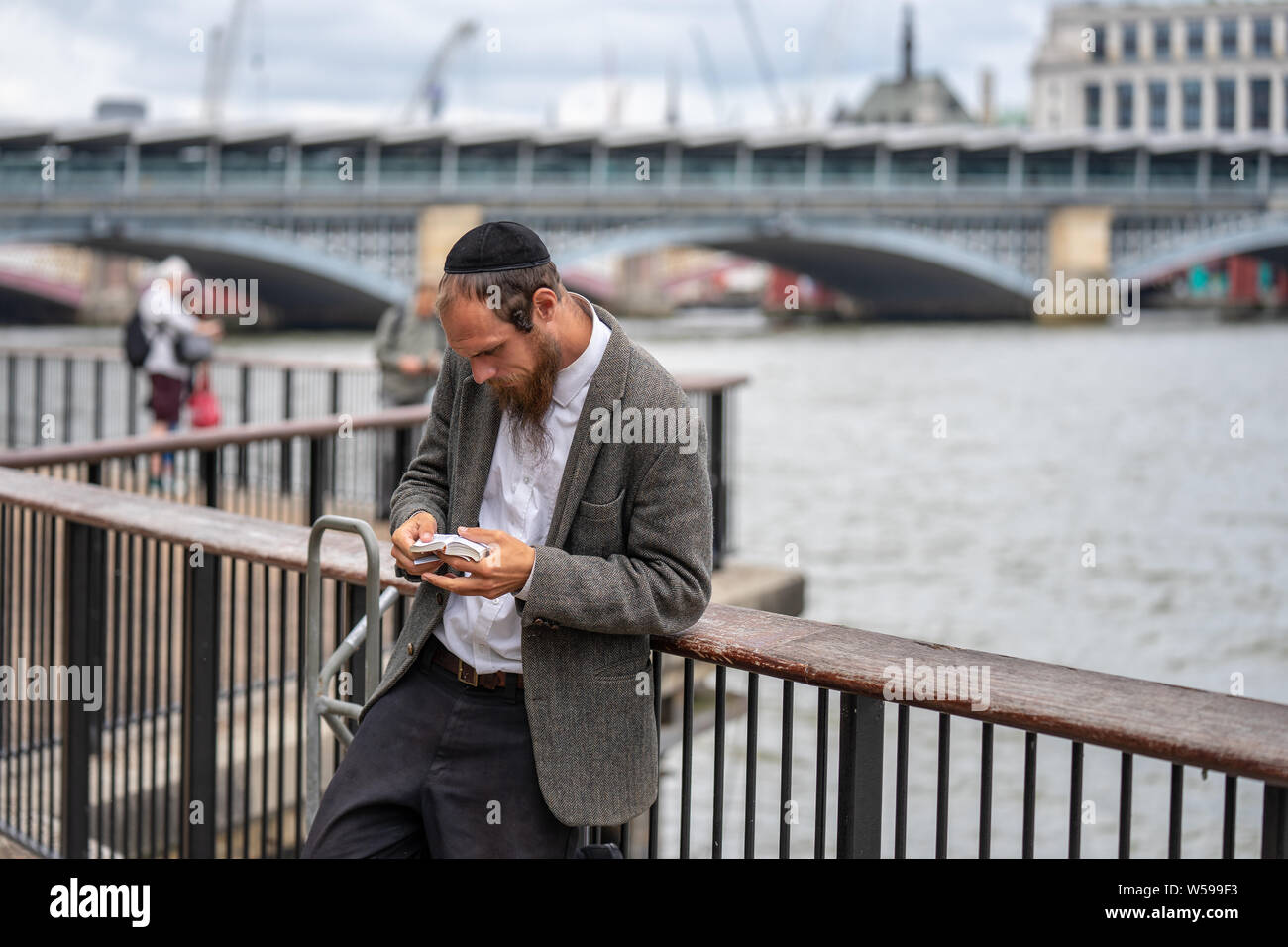 Londra, UK, luglio 2019. Close-up di ebreo ortodosso pregando con un libro in mano Foto Stock