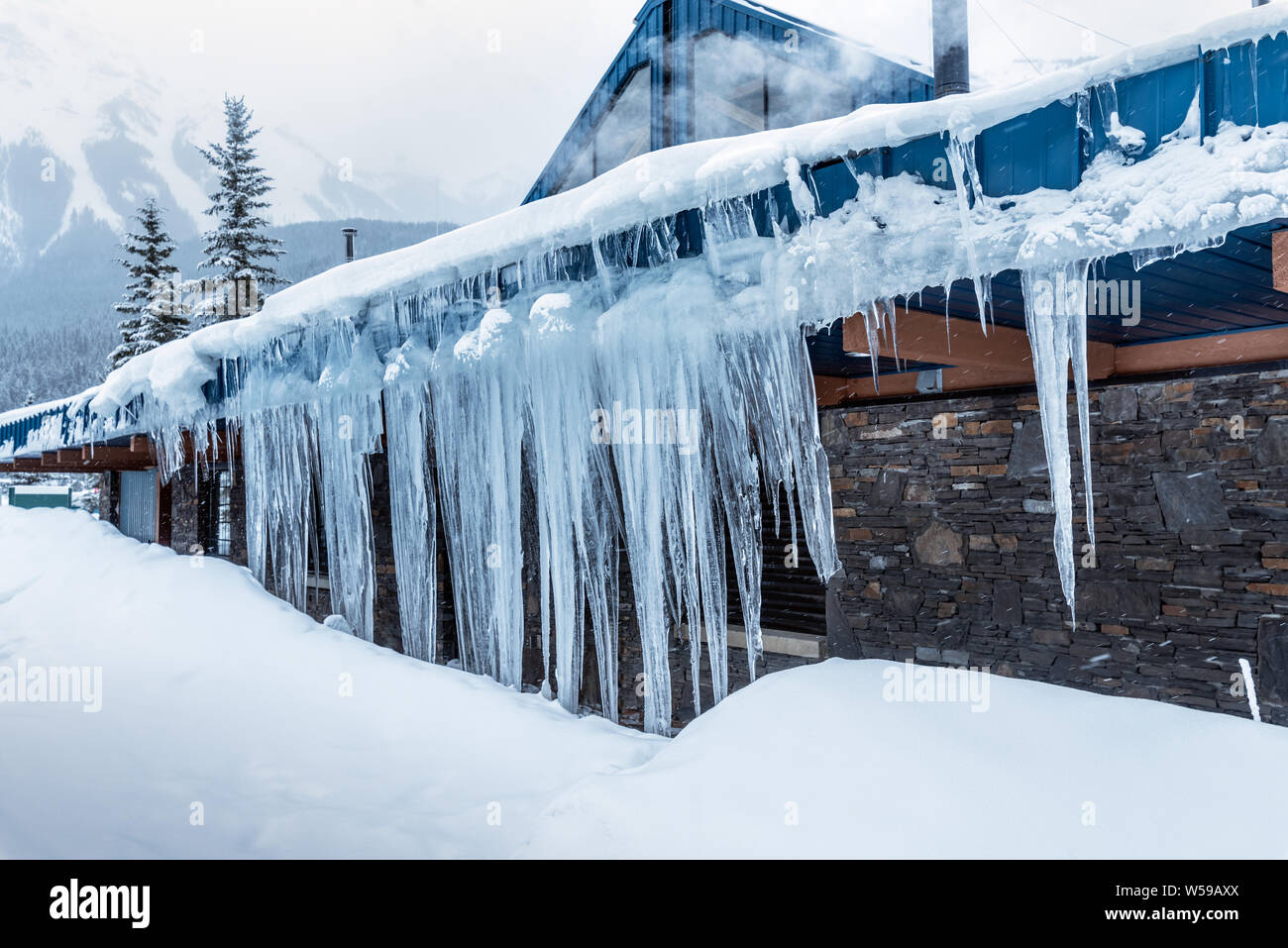 Ghiaccioli sul cornicione di un edificio in campo, British Columbia, Canada Foto Stock