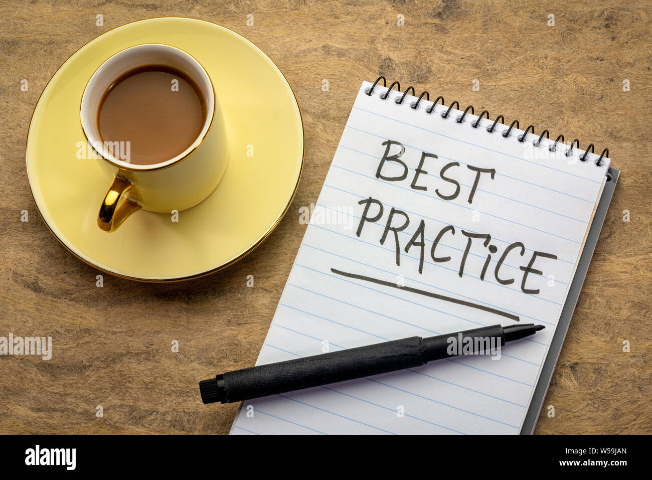 Best practice - la grafia in un notebook a spirale con una tazza di caffè Foto Stock