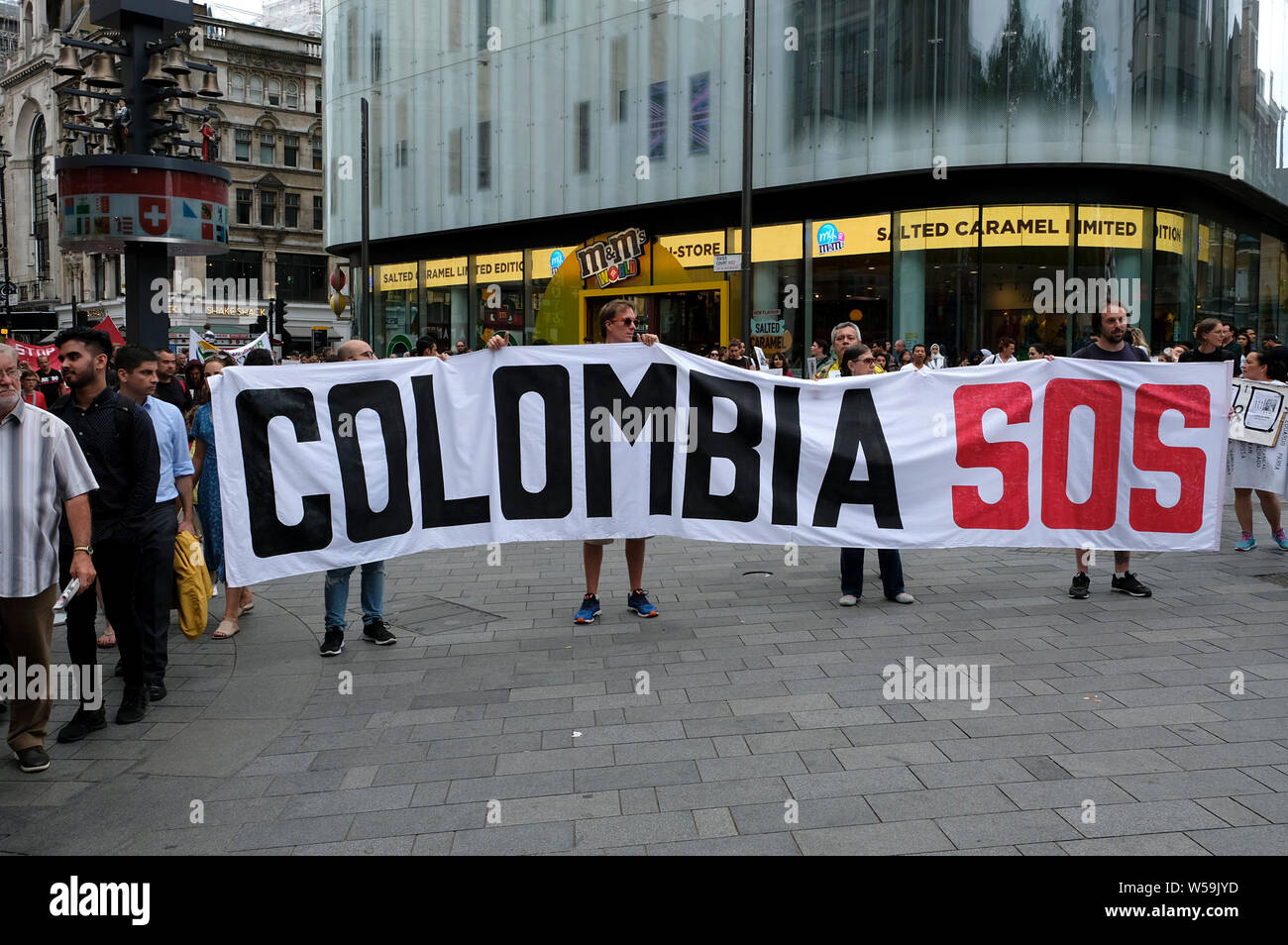 I dimostranti sono visti tenendo un grande striscione durante la protesta a Londra che recita "Colombia SOS'. I colombiani si sono riuniti al di fuori della BBC a Londra per protestare contro le continue uccisioni di leader di comunità, attivisti sociali, e le FARC ex guerriglieri, in Colombia. Essi hanno marciato attraverso il centro di Londra a Piazza del Parlamento tenendo un lungo banner con i nomi dei più di 700 dirigenti sociali che sono stati uccisi in Colombia Negli ultimi tre anni. I manifestanti sostengono la pace e i diritti umani in Colombia e la domanda al governo di prendere azione diretta a proteggere i leader delle comunità, il rispetto umano Foto Stock