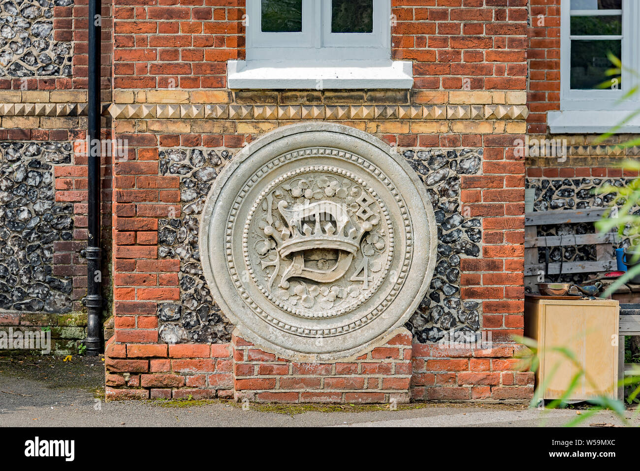 Cresta di pietra in Cobham scuola di villaggio Foto Stock