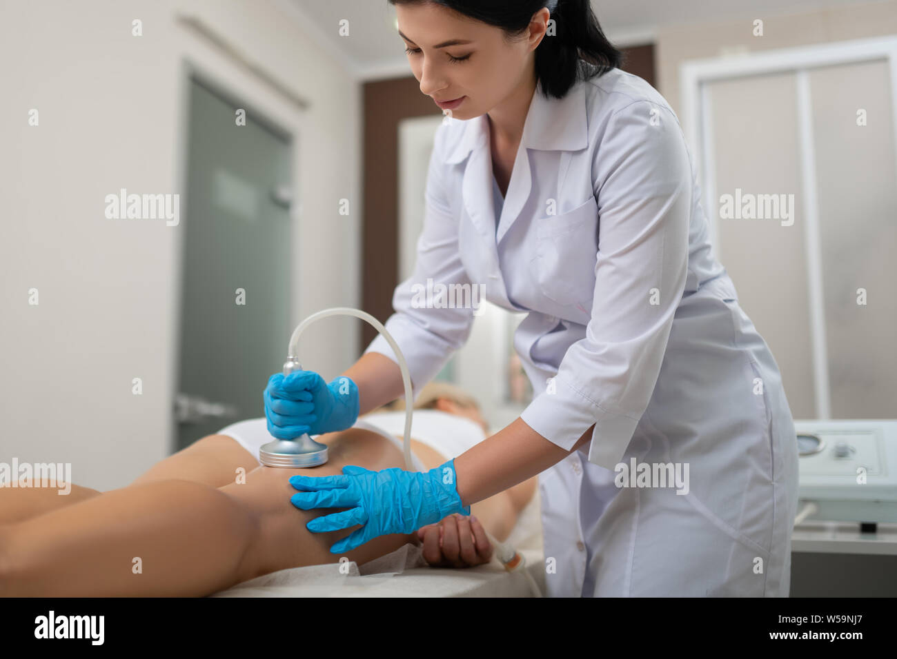 Bellezza medico facendo il suo client massaggio dell'anca. Foto Stock