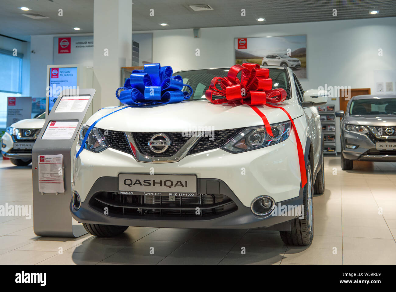 ST. PETERSBURG, Russia - Luglio 09, 2019: Il venduto auto Nissan Qashqai (2019) con due archi di colore rosso e blu in showroom per auto Foto Stock