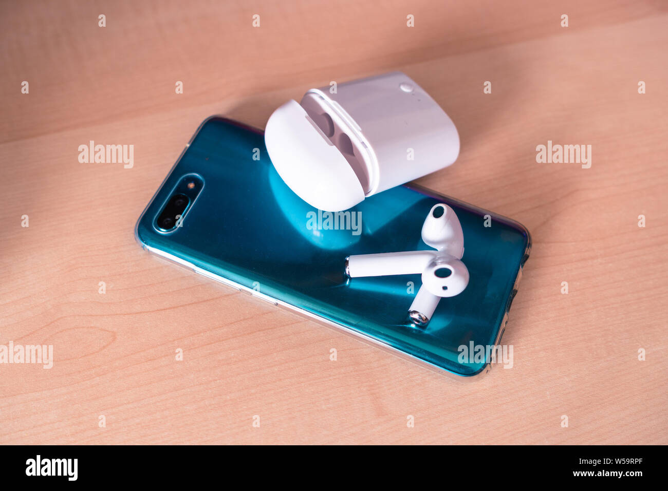 Green smartphone è pronto per essere di cattura con le nuove cialde di bluetooth su di esso con il caso bianco Foto Stock