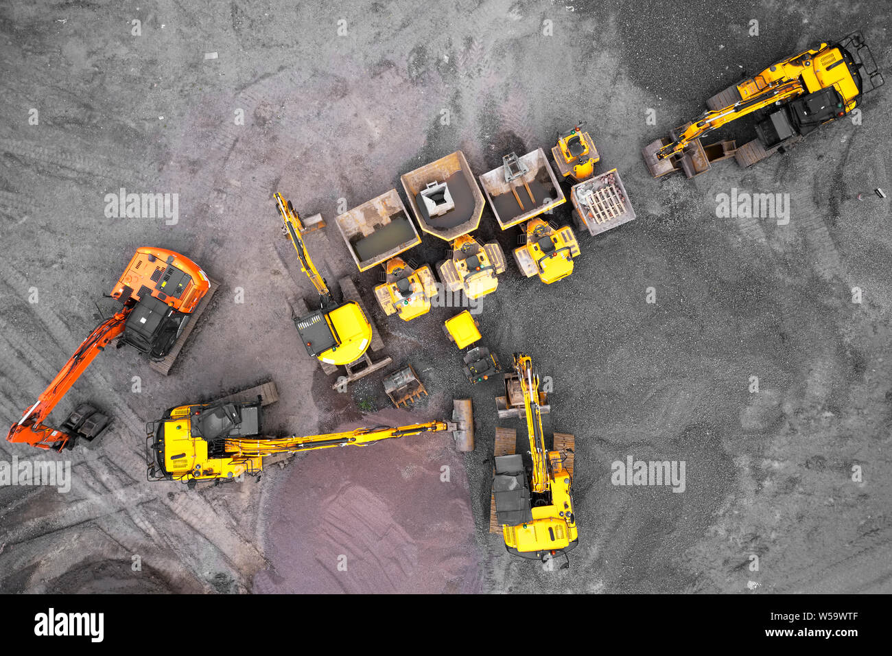 Sito in costruzione escavatrice giallo e arancione vista aerea da sopra Foto Stock