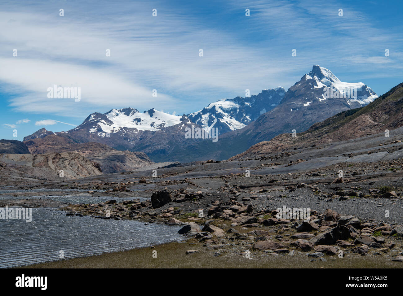 Si affaccia su una roccia disseminata e arida in primo piano fino alle Ande Mountains, Argentina Foto Stock