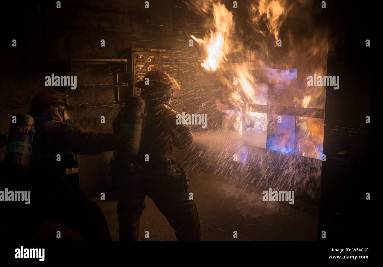 USS Carl Vinson marinai lotta una sala lavanderia incendio in una lotta antincendio training facility a Bremerton, Washington, 24 luglio 2019. (U.S. Foto di Marina di Massa lo specialista di comunicazione 2a classe Dylan M. Kinee/rilasciato) Foto Stock