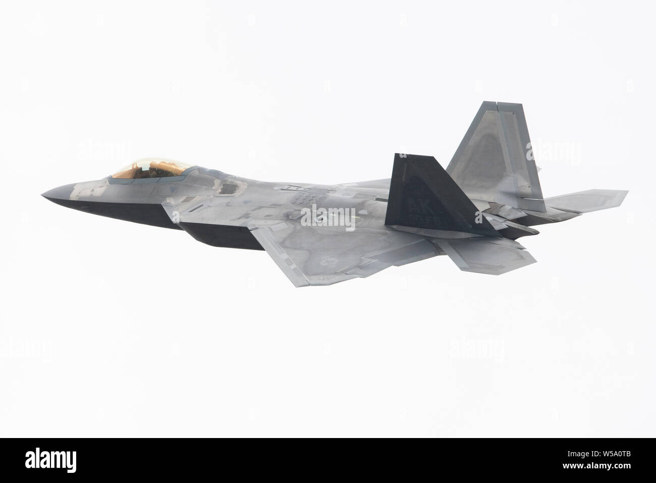 Stati Uniti Air Force Il Mag. Joshua "Cabo" Gunderson, un F-22 Raptor pilota con il novantesimo Fighter Squadron esegue una dimostrazione di antenna per gli spettatori durante la terza ala il centesimo anniversario celebrazione che si tiene a base comune Elmendorf-Richardson, Alaska, Luglio, 26, 2019. Gli eventi inclusi un aerodromo 5K run, un F-22 Raptor dimostrazione, un F-22 carico di armi crew concorrenza e un tradizionale roll call e pianoforte di masterizzazione. (U.S. Air Force foto di Alejandro Peña) Foto Stock