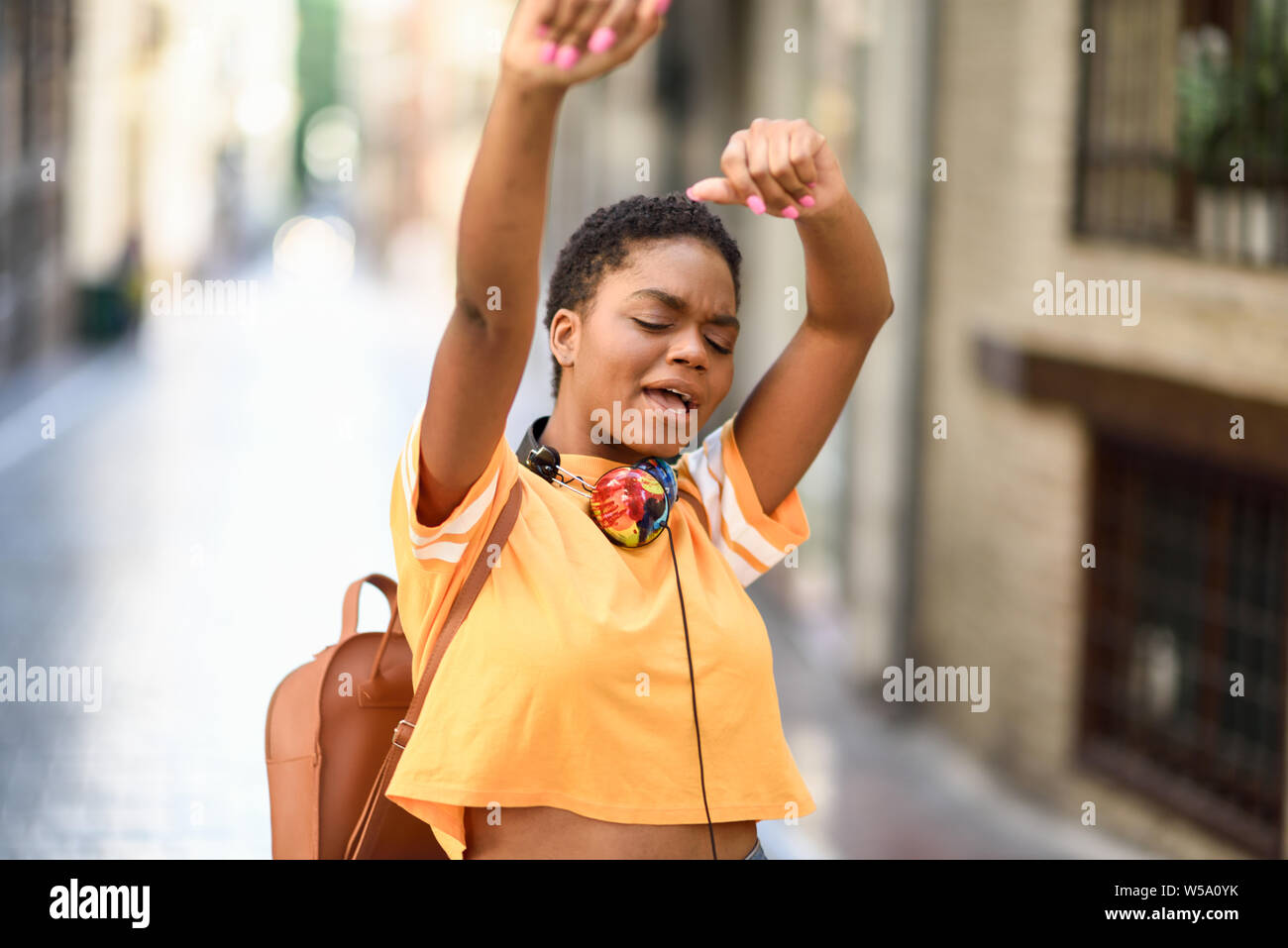 Giovane donna nera sta ballando sulla strada in estate. Ragazza che viaggiano da soli. Foto Stock