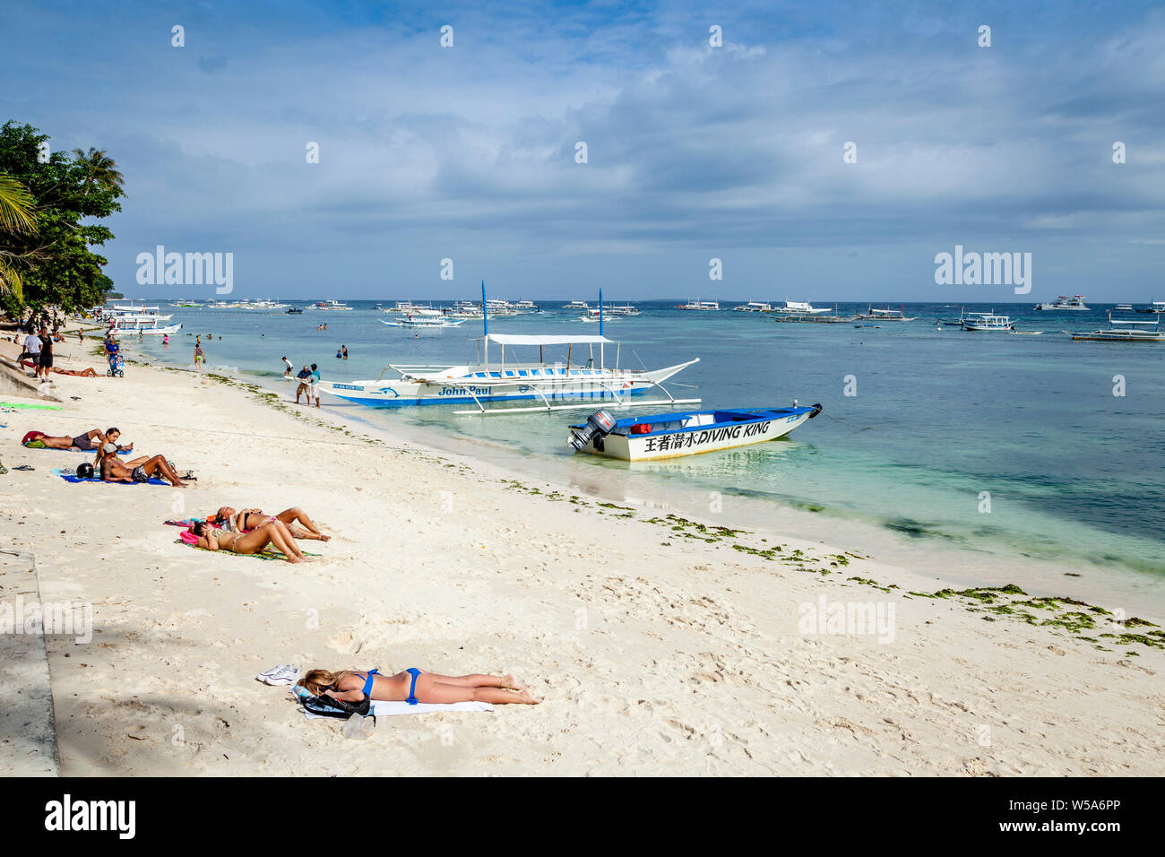 I giovani a prendere il sole su Alona Beach, Bohol, Filippine Foto Stock