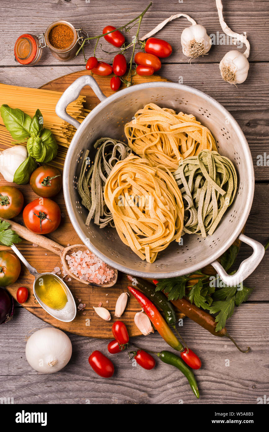 Composizione con gli ingredienti per cucinare le tagliatelle con pomodoro, basilico, olio d'oliva e parmigiano. Foto Stock