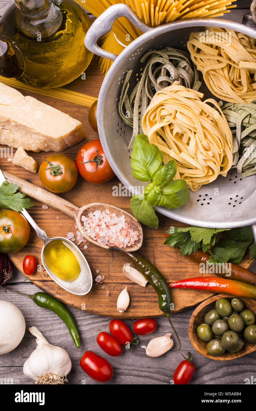 Composizione con gli ingredienti per cucinare le tagliatelle con pomodoro, basilico, olio d'oliva e parmigiano. Foto Stock