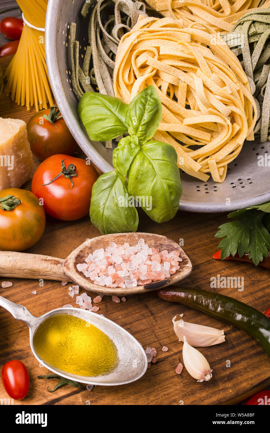 Composizione con gli ingredienti per cucinare le tagliatelle con pomodoro, basilico, olio d'oliva e parmigiano. Foto Stock