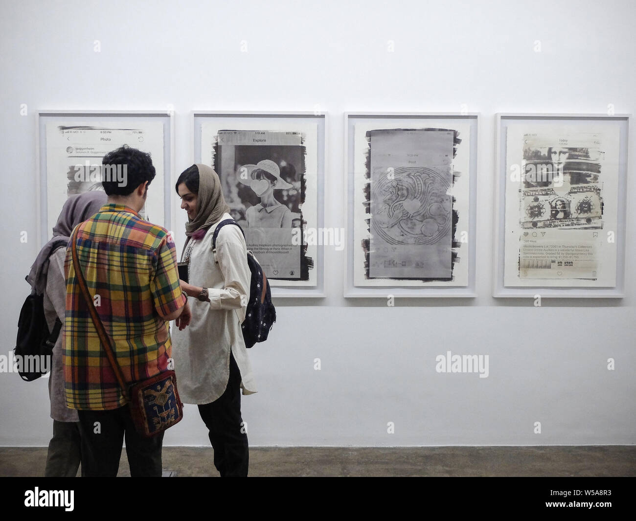 Luglio 26, 2019, Teheran, Teheran, Iran: la gente visita Vahid Dashtyari e Mehdi Khandan foto della mostra alla Galleria Mohsen nel centro di Teheran, Iran. Il due-uomo mostra fotografica da Vahid Dashtyari e Mehdi Khandan è circa alternative processi fotografici, vale a dire gelatina argento e cyanotype, per registrare la realtà: uno è in cerca di recuperare la perdita di spirito di fotografia e ripristina qualcosa di falso per la sua forma originale, mentre l'altra è la ricerca per l'anima perduta della città, cambiare qualcosa di autentico di una contraffazione. Credito: Rouzbeh Fouladi/ZUMA filo/Alamy Live News Foto Stock