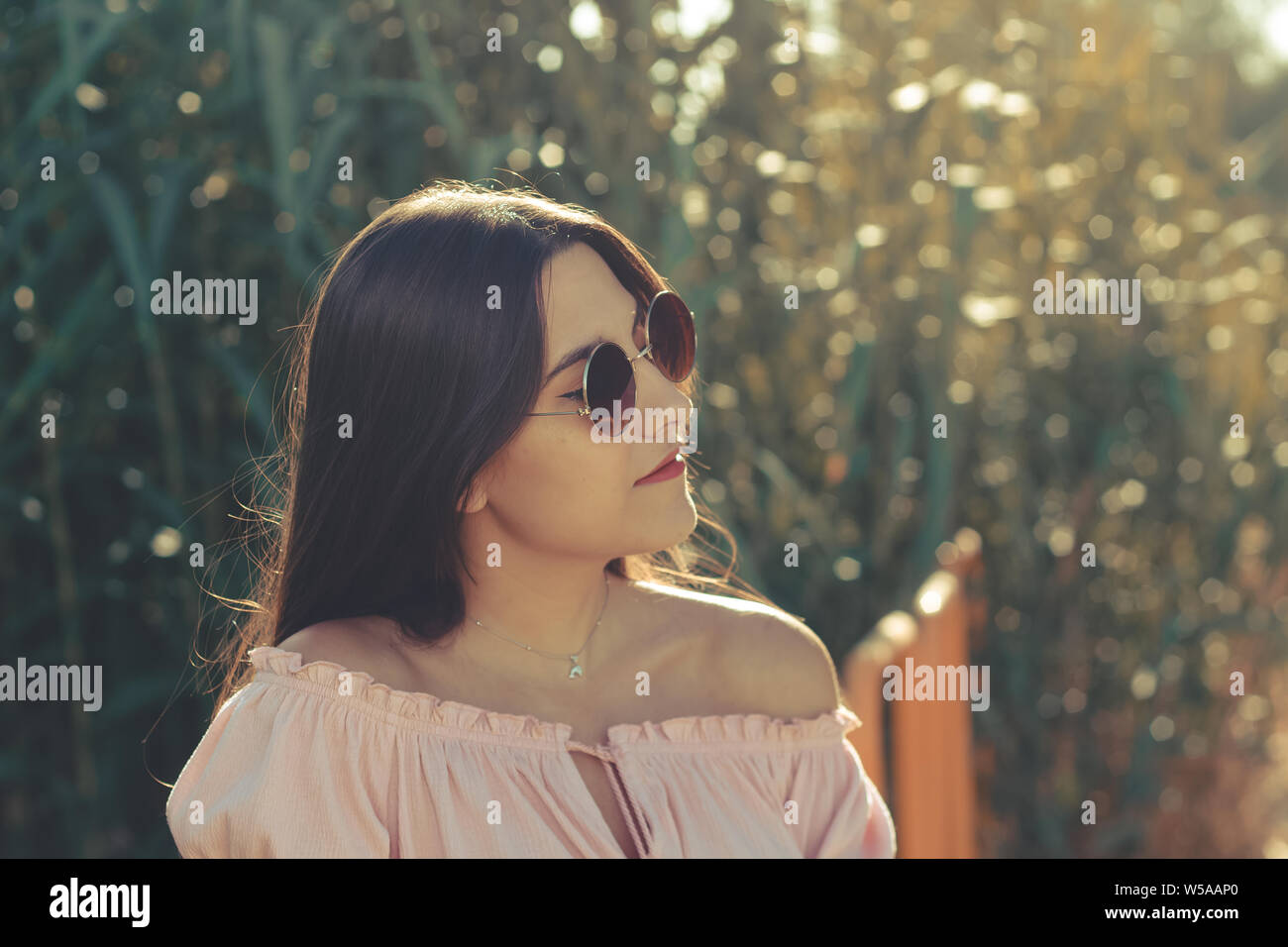 Ritratto di una bella donna che indossa gli occhiali da sole all'aperto in un giorno di estate Foto Stock