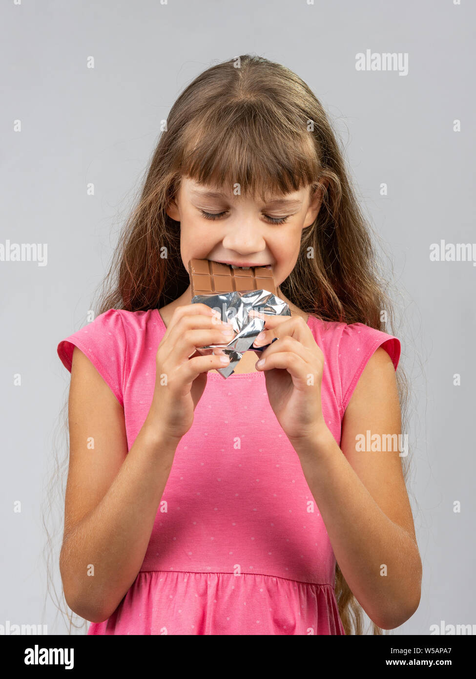 Teen ragazza con piacere i morsi di cioccolato Foto Stock