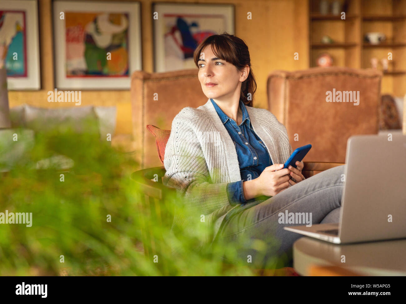 Donna al lavoro su un computer portatile su un comodo spazio Foto Stock