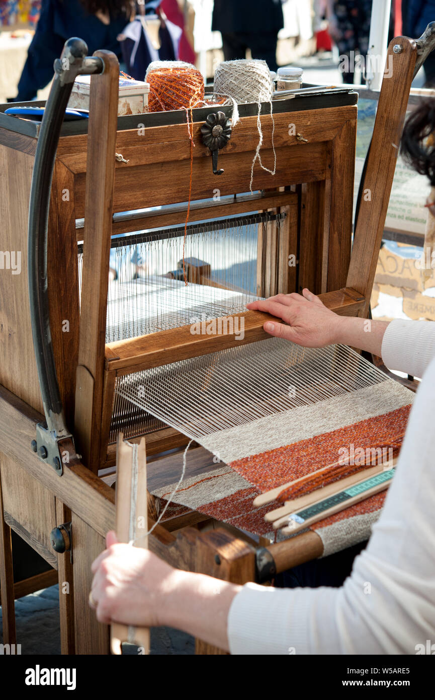 Chiudere fino a mani della donna di colore di tessitura sul modello tradizionale di tessitura a mano telaio in legno. Foto Stock