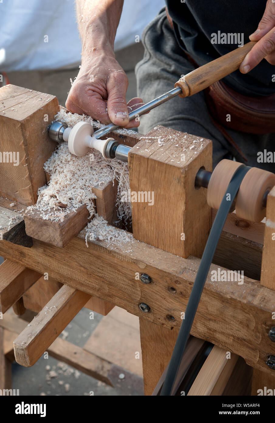 Un artigiano si ritaglia un pezzo di legno utilizzando un tornio manuale Foto Stock