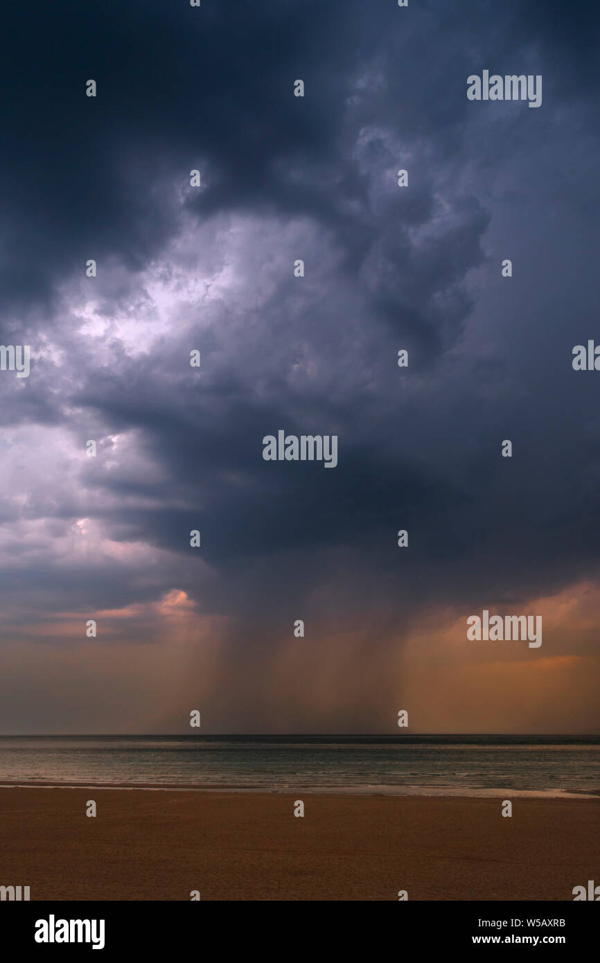 Tempesta che mostra oscura pioggia nuvole e cloudburst / diluvio sul mare durante la canicola / ondata di caldo in estate Foto Stock