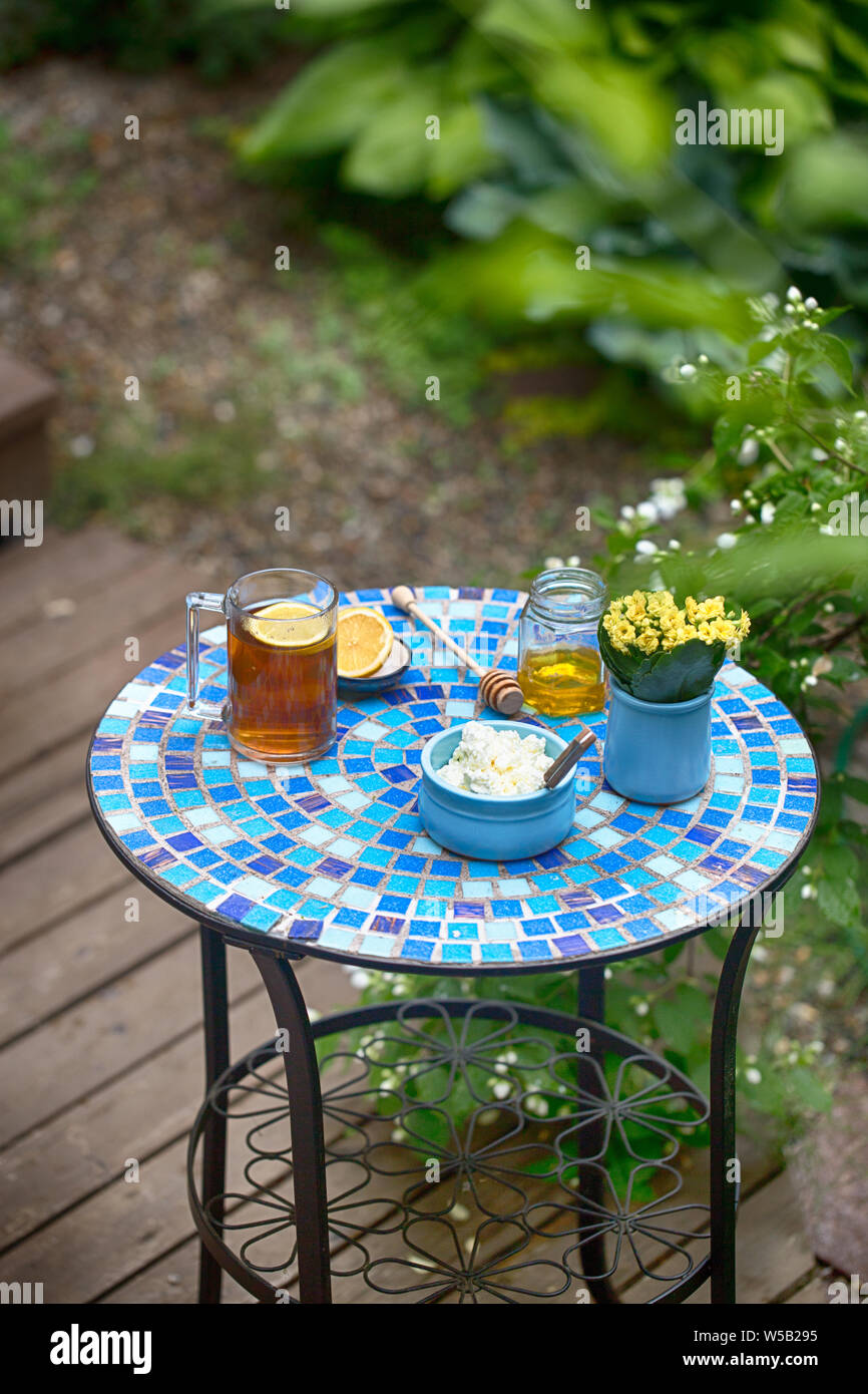 La colazione del mattino tavola in country house cottage cheese tè blu miele piccolo tavolo in mosaico Foto Stock