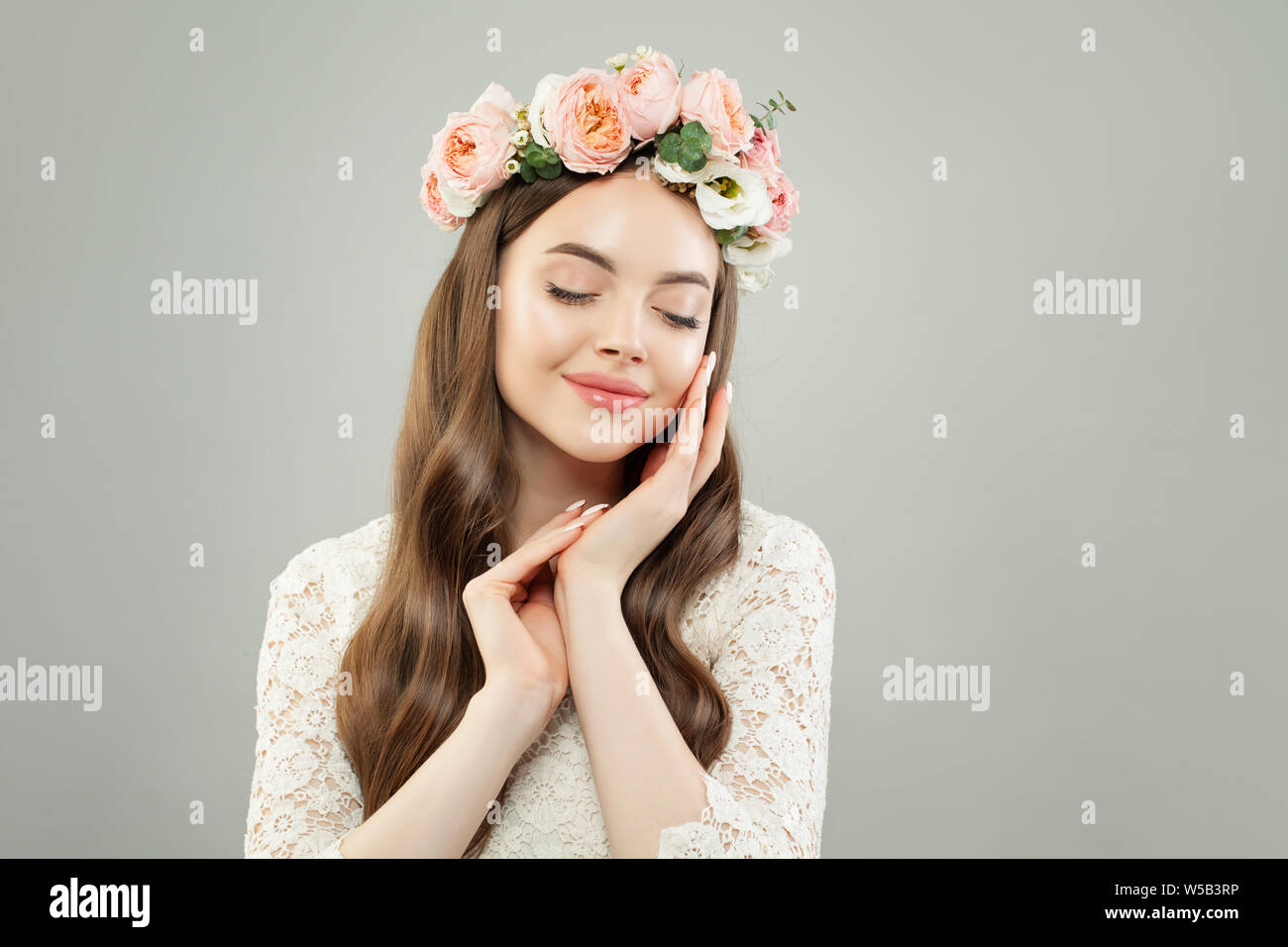 Carino donna con pelle chiara, lunghi capelli luminosi e rilassanti dei fiori Foto Stock