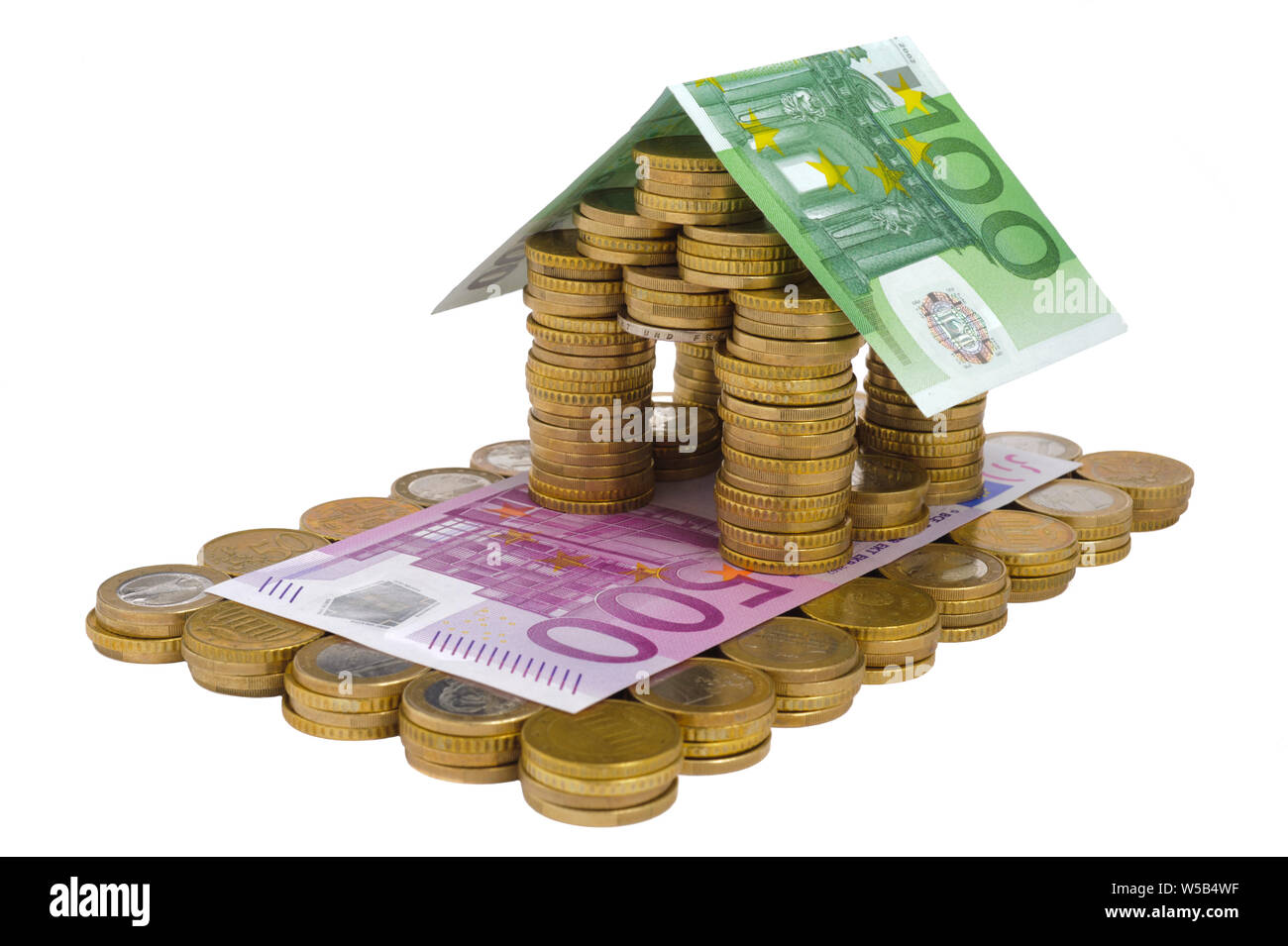 Casa modello costruito con banconote e monete metalliche in euro Foto Stock