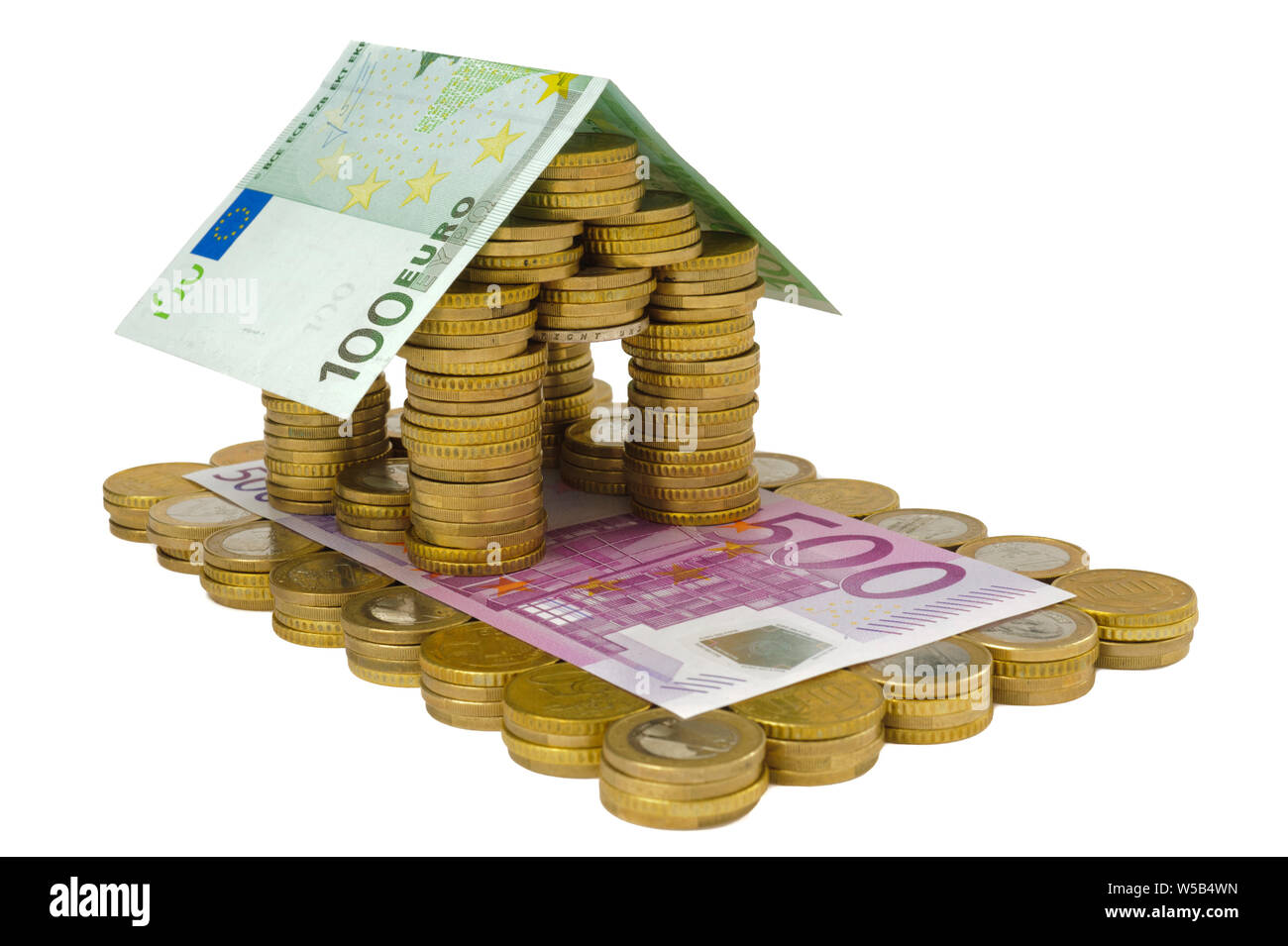 Casa modello costruito con banconote e monete metalliche in euro Foto Stock