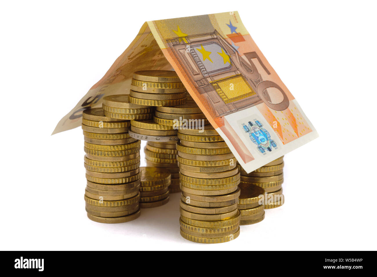 Casa modello costruito con banconote e monete metalliche in euro Foto Stock