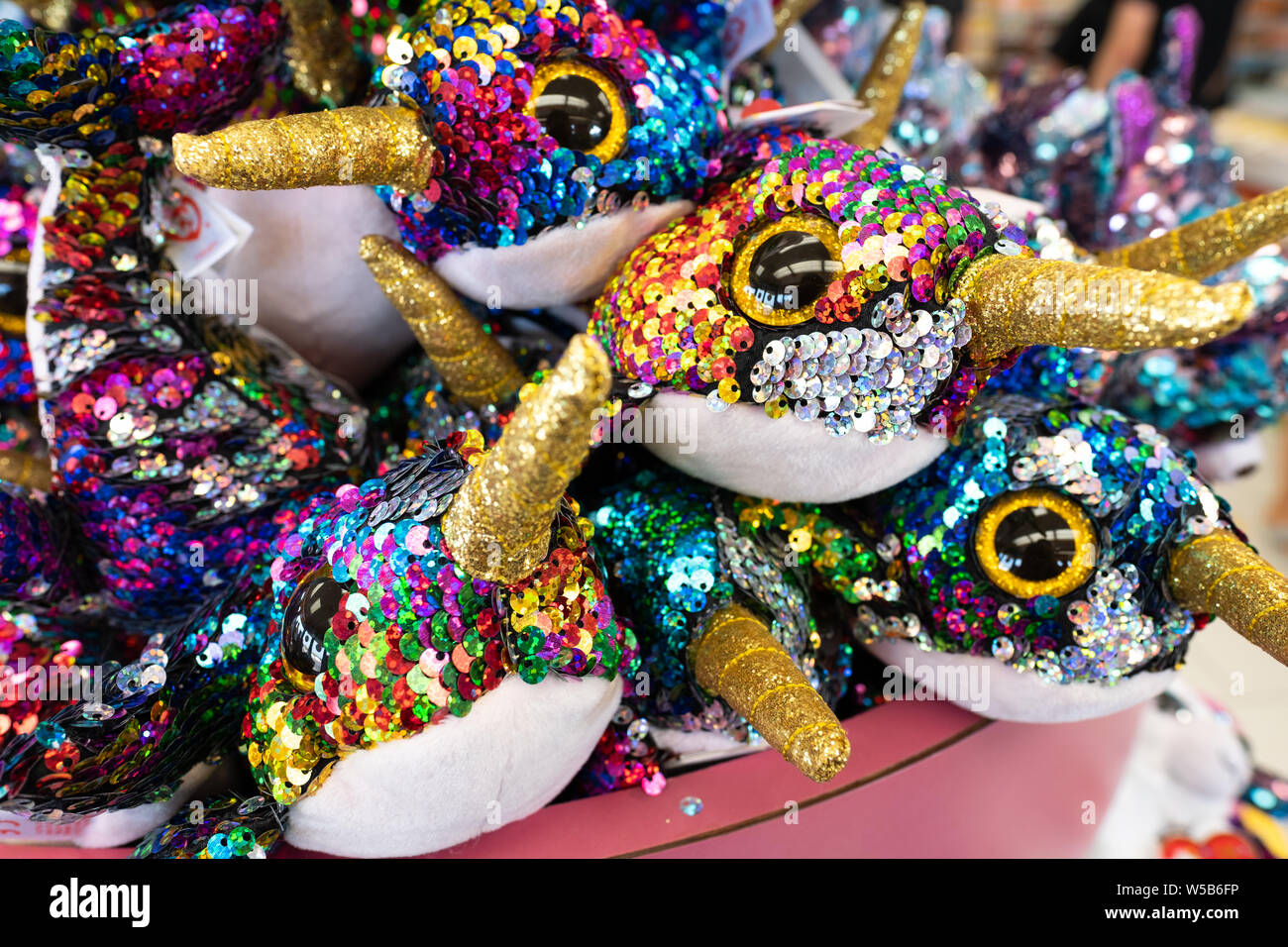 Colorate unicorns imbottito coperto di paillettes in vendita in un negozio. Foto Stock