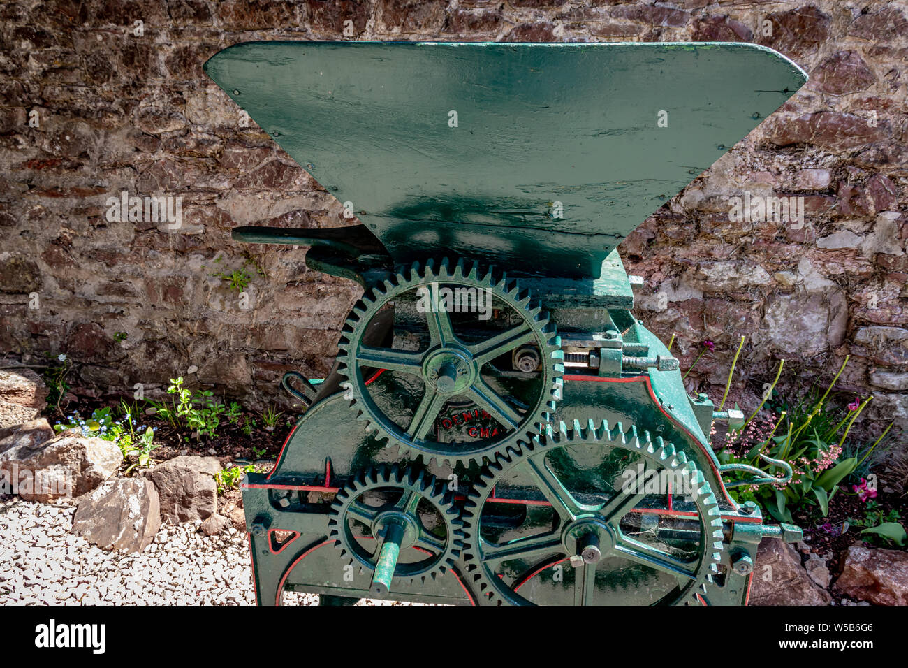 Ripristino vecchio portatile granella Vintage /frantumatore di frumento con Tramoggia in legno nel Devon Village .UK Foto Stock