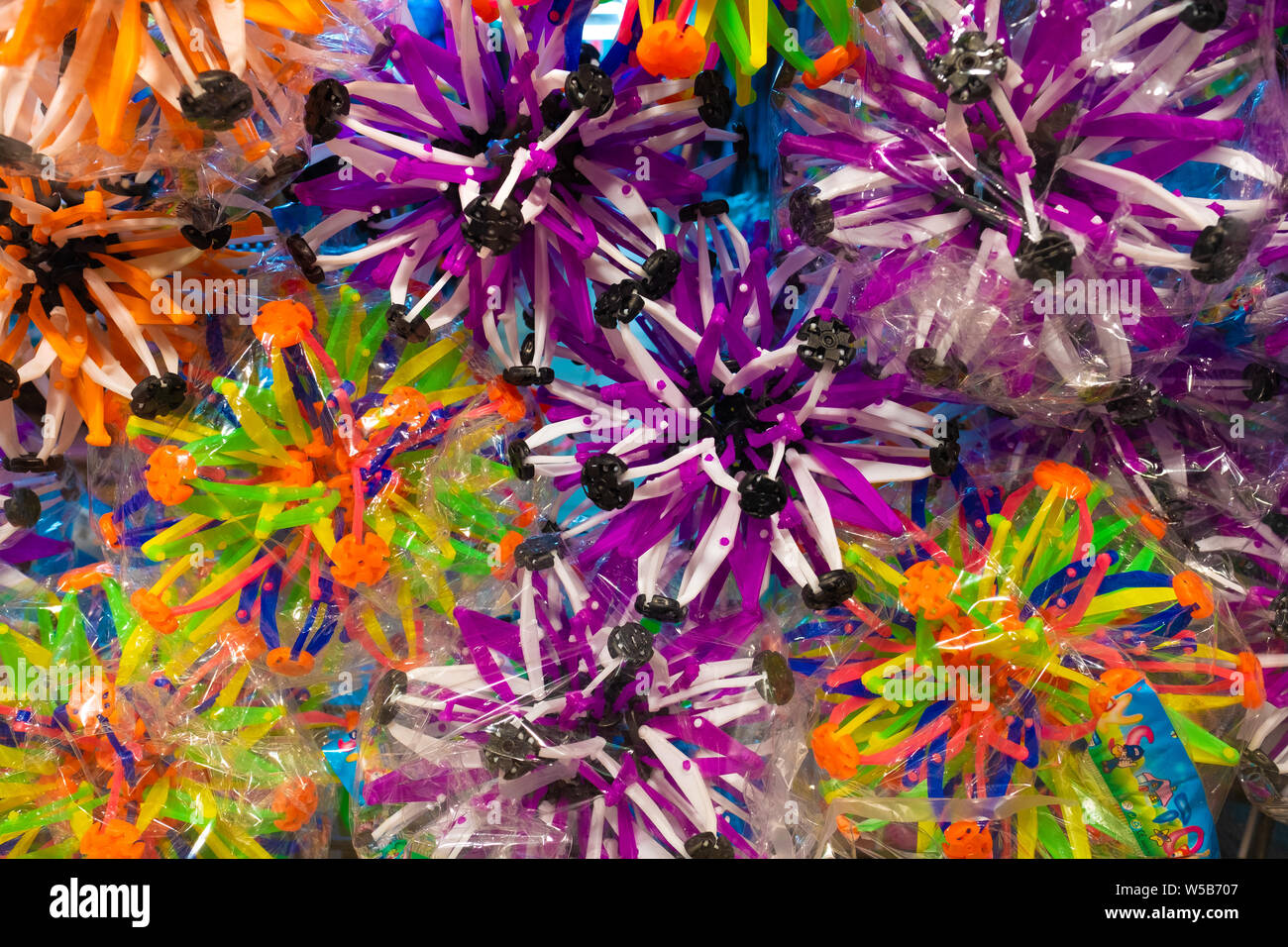 Palle colorate in plastica con punte a incastro confezionate in un involucro trasparente per la vendita presso un mercato o un negozio di giocattoli Foto Stock
