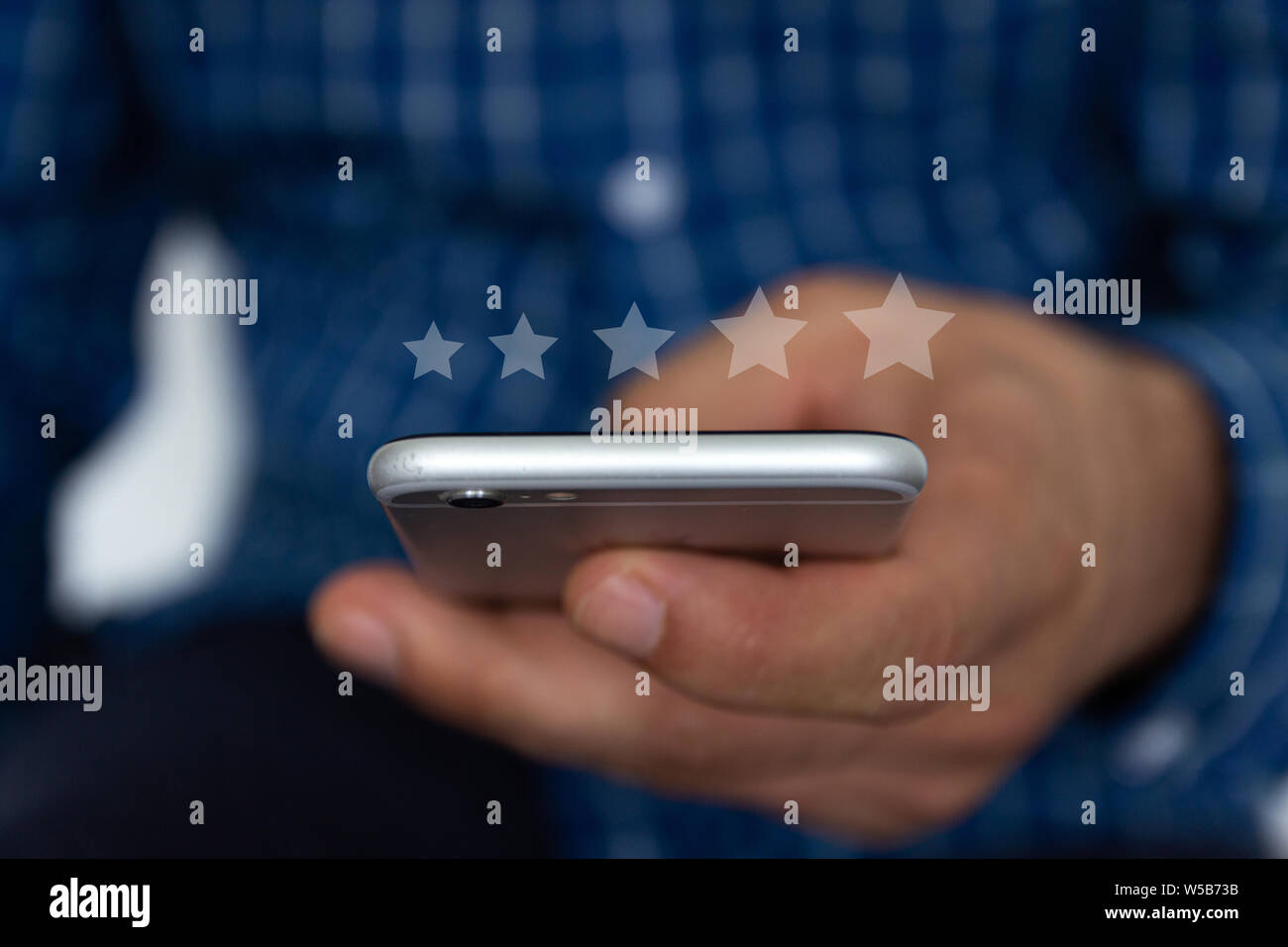 Il servizio clienti, l'analisi delle prestazioni. Un man mano utilizzando smart phone con icona cinque stella simbolo per aumentare il rating della società Foto Stock