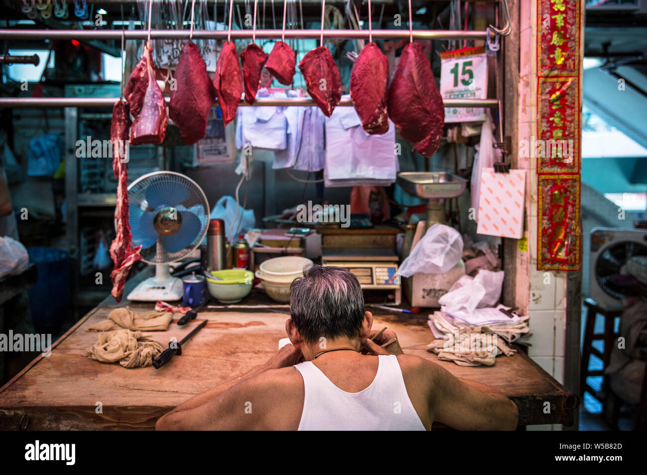 Butcher mettendo in pausa per mangiare a Fa Yuen mercato. Hong Kong Foto Stock