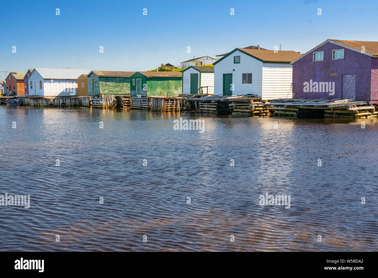 La colorata Vecchia capannoni di pesca lungo l'oceano in Terranova, Canada Foto Stock