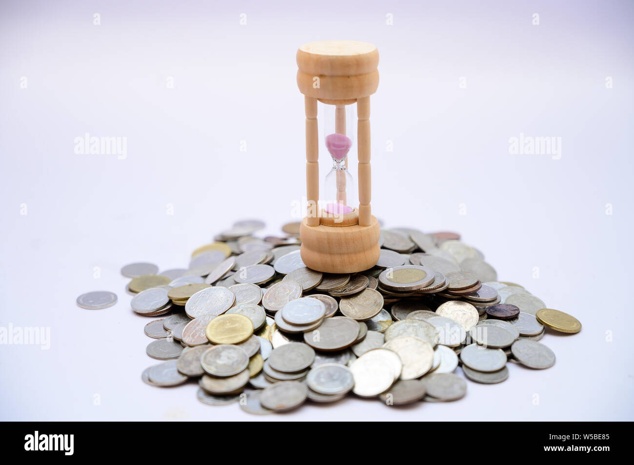 Clessidra e moneta il concetto di tempo e risparmio di denaro Foto Stock