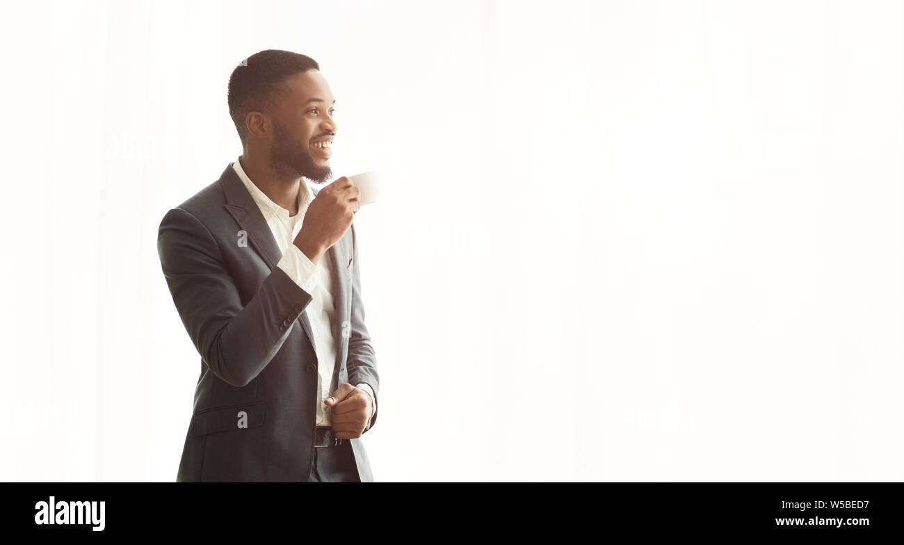 African American businessman godendo cityview dalla finestra in ufficio Foto Stock