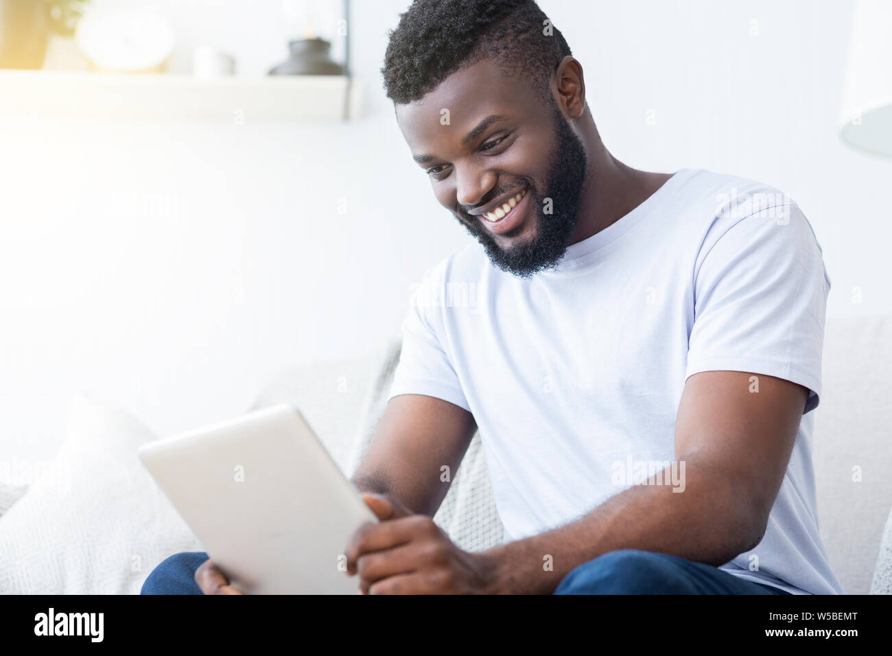 Afro-americano a guardare il filmato su tablet in ambienti interni Foto Stock