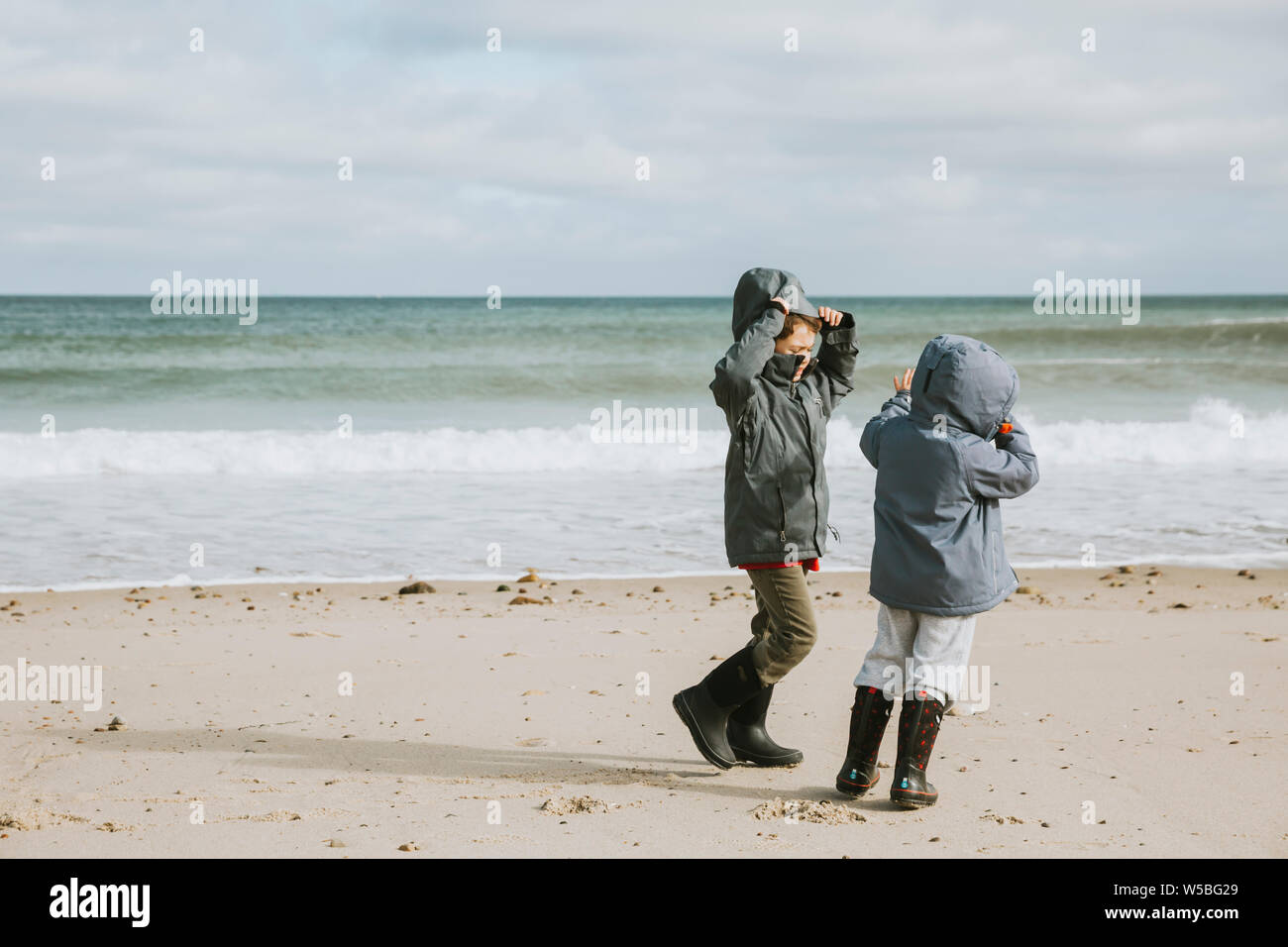 Due fratelli sulla spiaggia spazzate dal vento Foto Stock