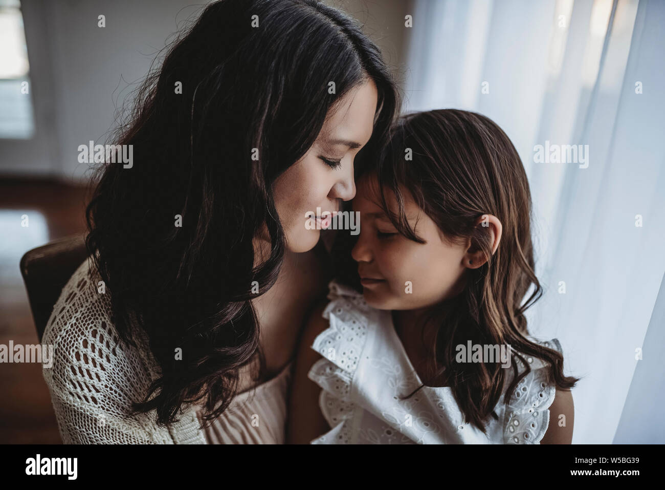 Vista ravvicinata della madre e figlia di toccare fronte Foto Stock