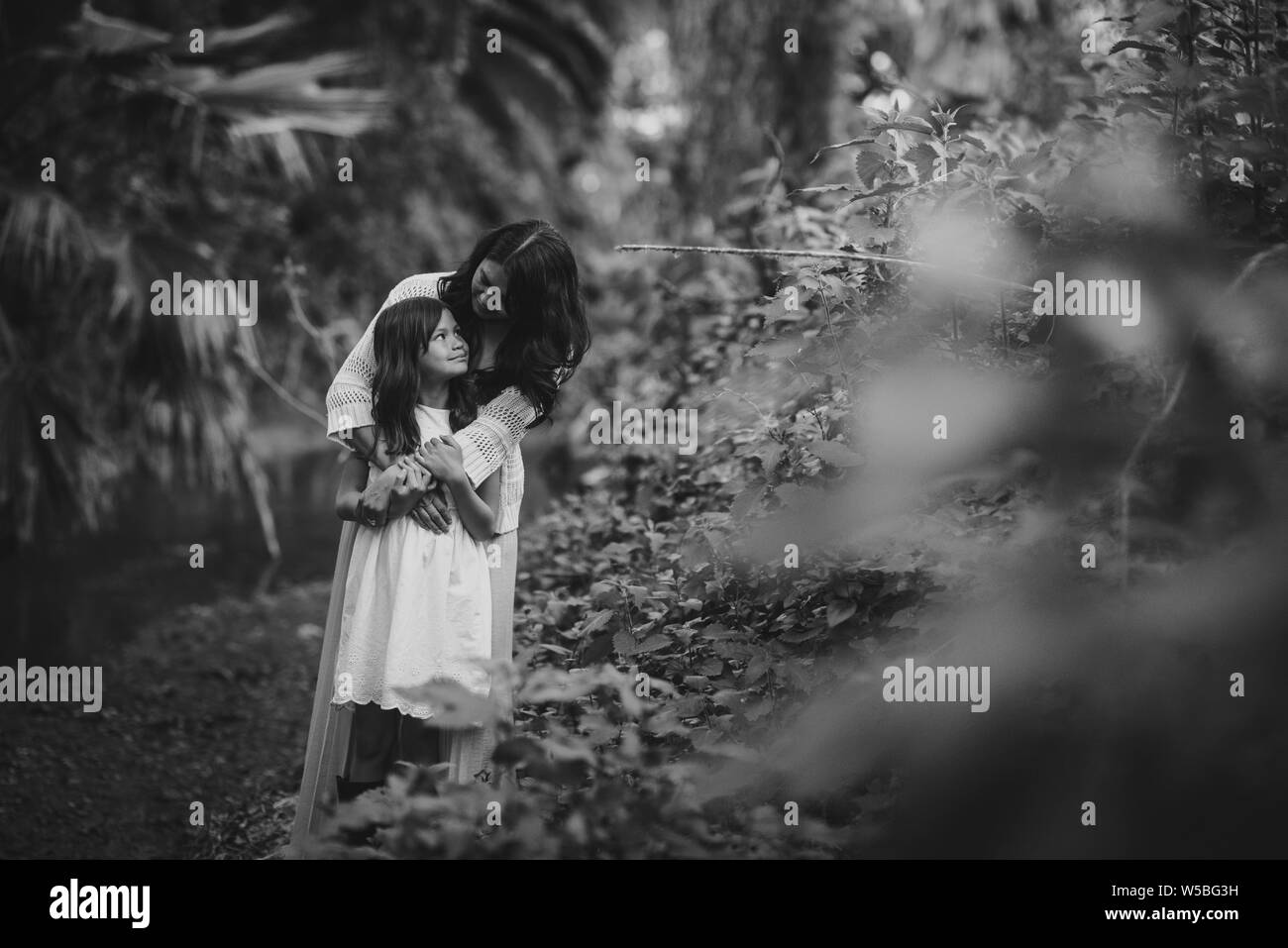Madre e figlia abbracciando e guardando ogni altra nei boschi Foto Stock