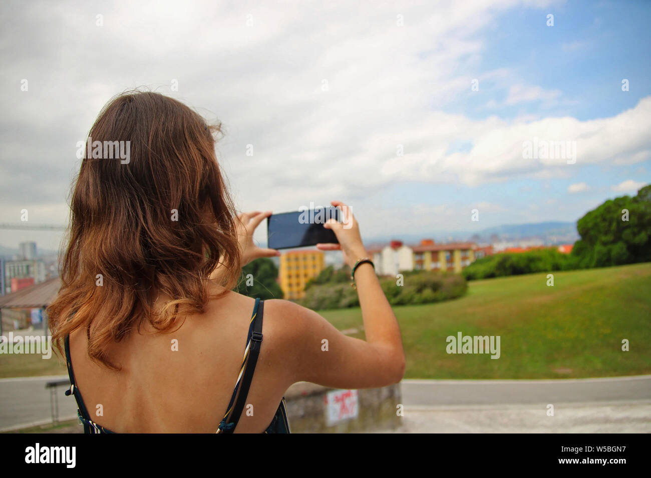 Giovane donna di scattare una foto del paesaggio. Foto Stock