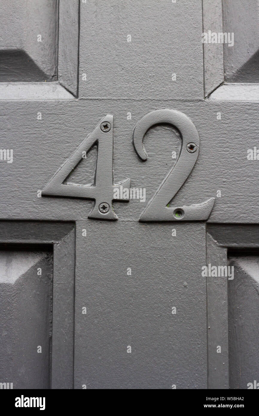 Grigio elegante casa numero 42 con i quaranta due nello stesso colore del legno porta anteriore Foto Stock