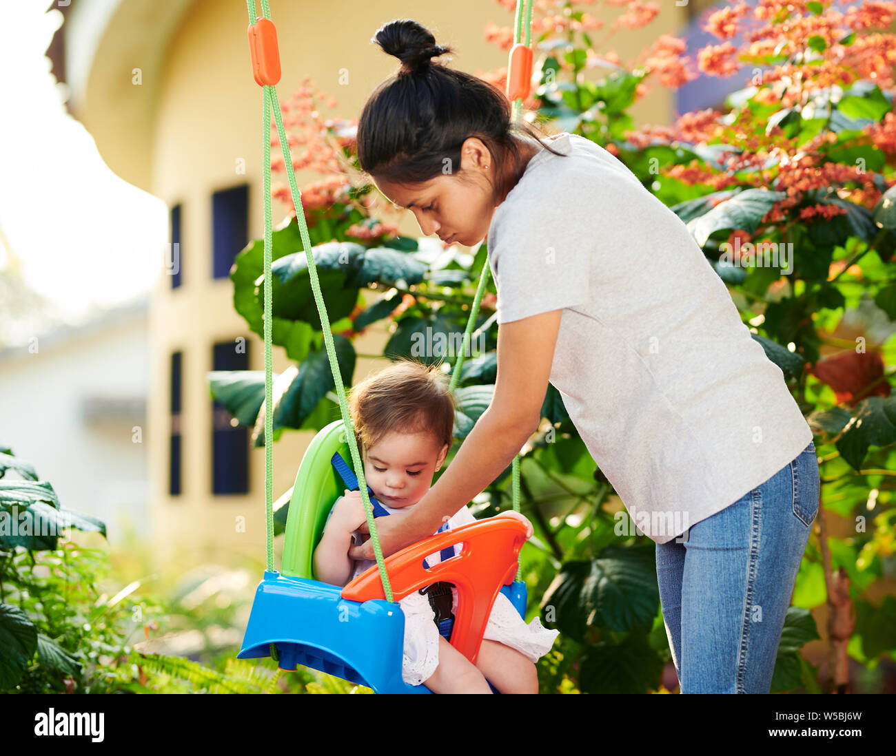 Baby sitter si prendono cura del bambino in casa sullo sfondo del giardino Foto Stock