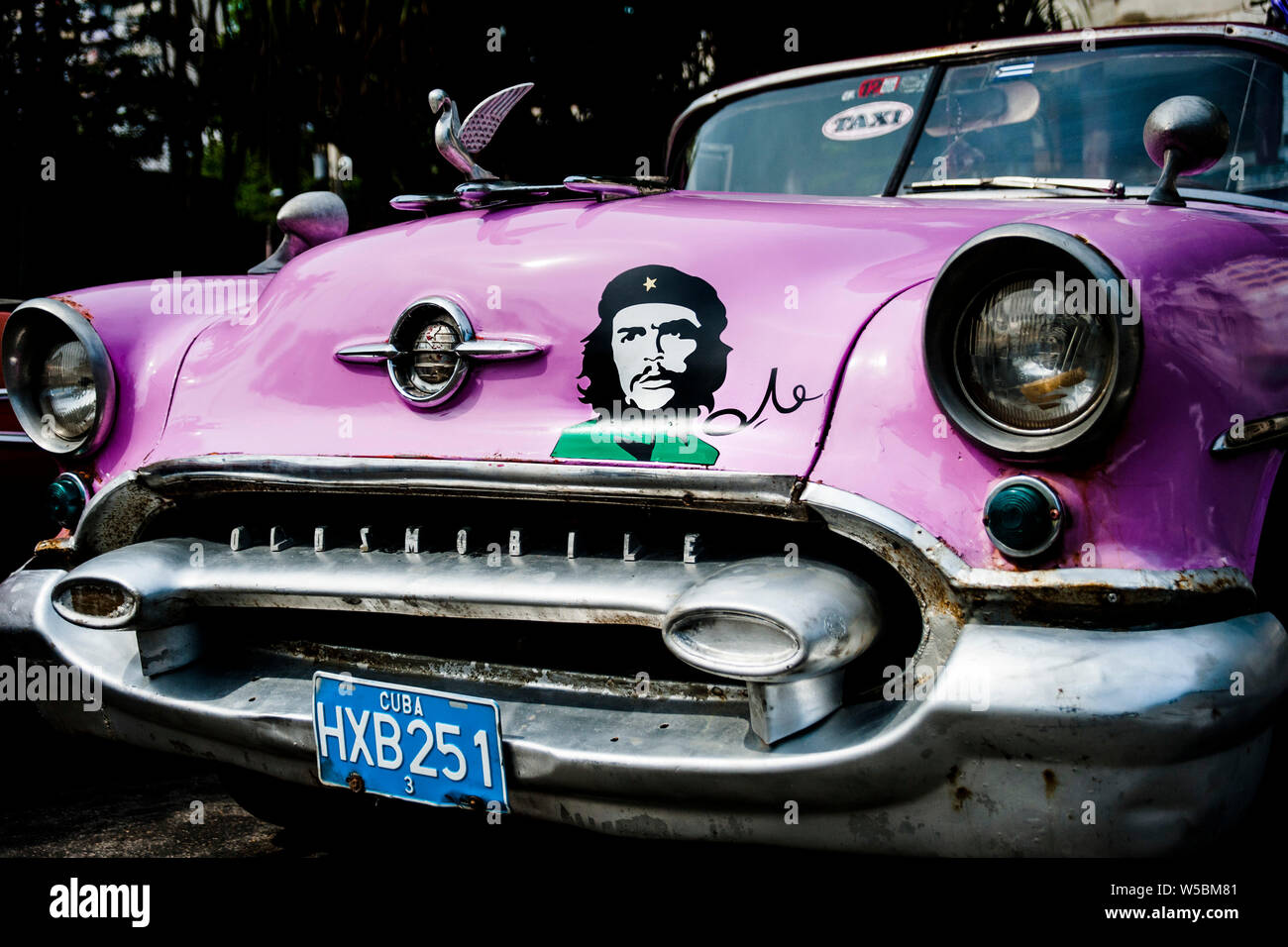 Immagine di eroe rivoluzionario e icona di Che Guevara sulla parte anteriore di un classico cubano auto taxi a l'Avana, Cuba Foto Stock